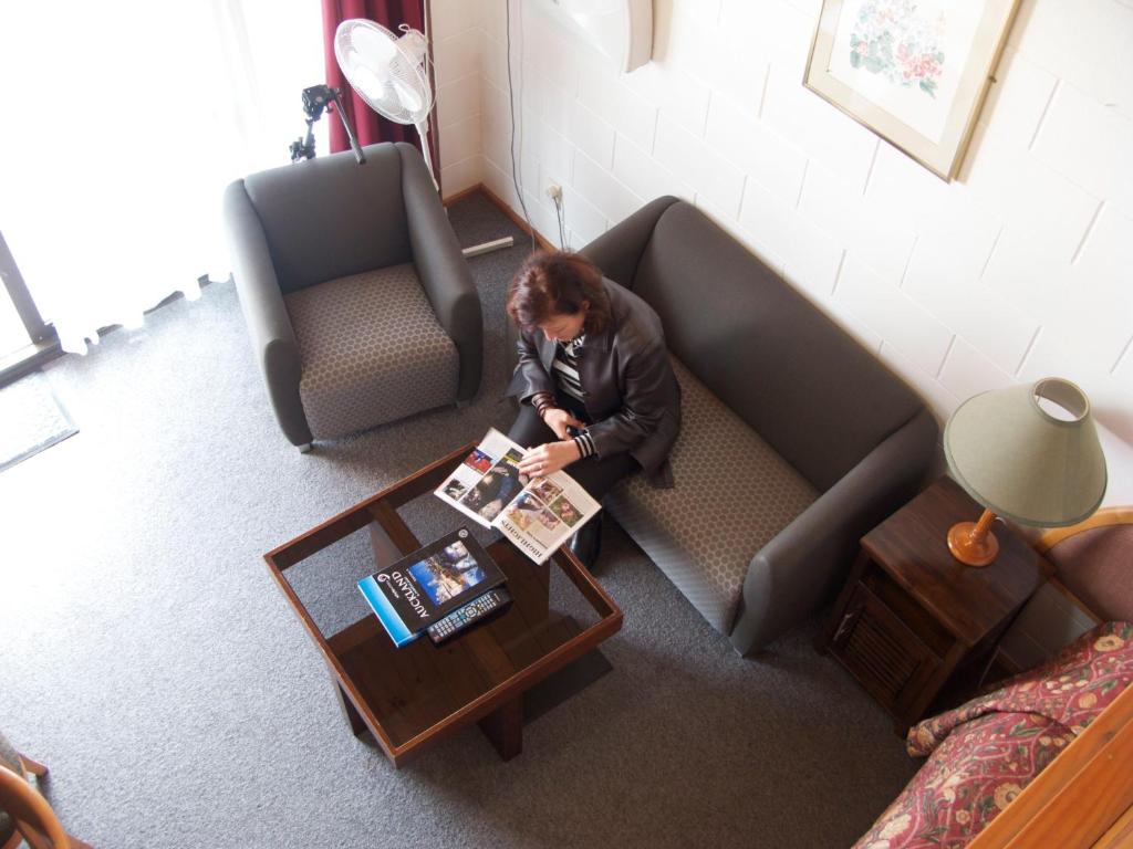 奥克兰纽黑文汽车旅馆 的坐在沙发上读杂志的人
