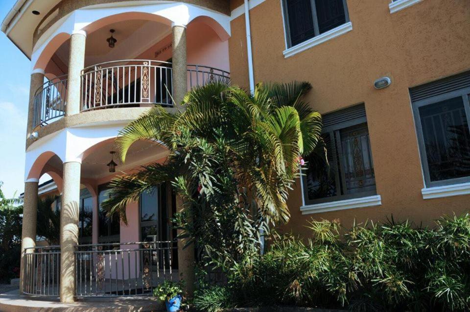 姆巴拉拉Palace Hotel的前面有棕榈树的建筑