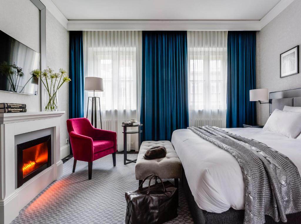 华沙Hotel Teatro Boutique Old Town的酒店客房配有一张床和一个壁炉。