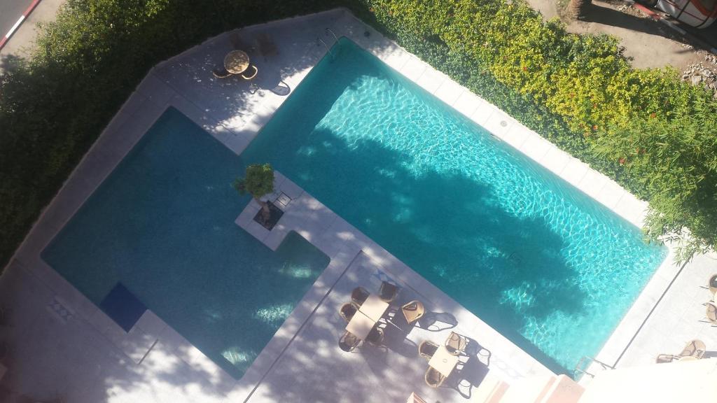 马拉喀什伊米勒希勒格兰德酒店的享有带2张躺椅的游泳池的顶部景致