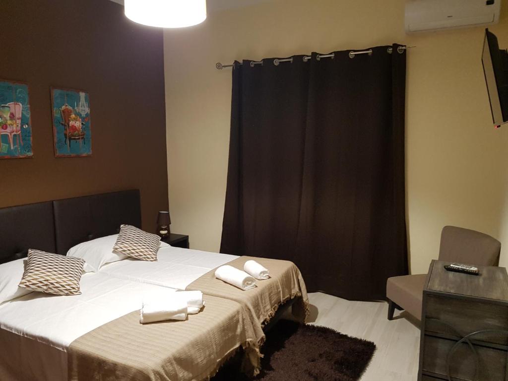 阿尔曼萨Almancil Hostel的一间卧室配有两张床和白色毛巾。