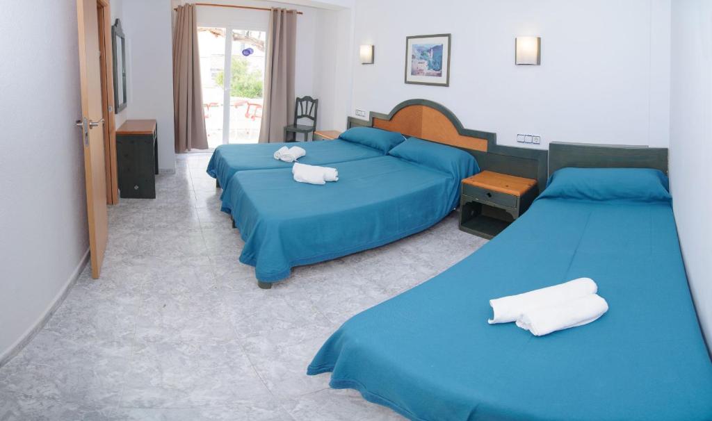 圣安东尼奥罗萨莉娅旅馆的卧室内的两张床,配有蓝色床单和白色毛巾