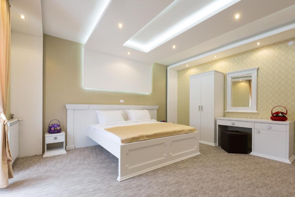 贝尔格莱德Hotel Sabor的卧室配有白色的床和镜子