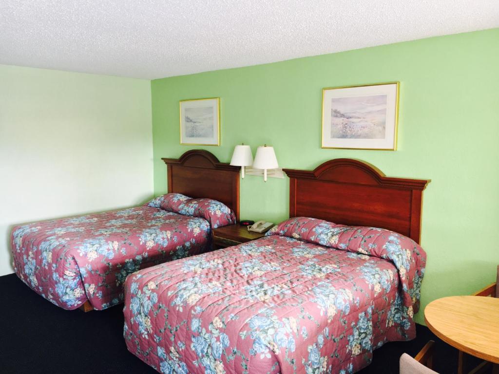 FolkstonRelax Inn的酒店客房设有两张床和一张桌子。