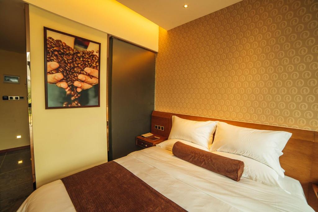 珠海喆·啡酒店珠海横琴长隆店的卧室配有一张床,墙上挂着一幅画