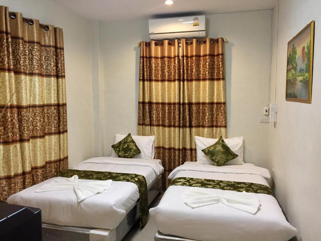 Ban Pa Sang (1)阿品萨雅旅馆的小型客房配有两张床和窗帘