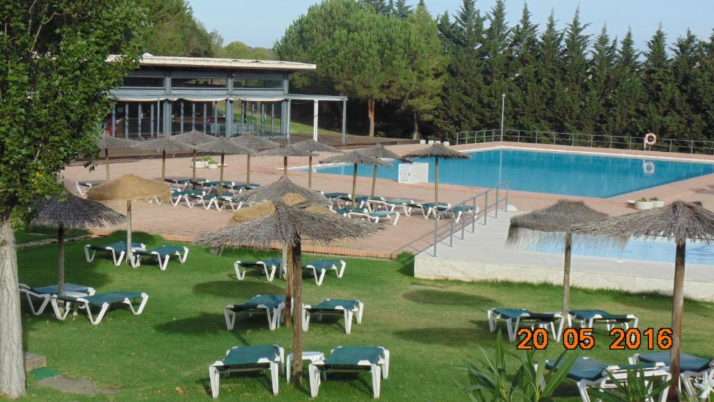 拉戈斯C16 - Landeiro MarinaPark Apartment的度假村前方的带椅子和遮阳伞的游泳池