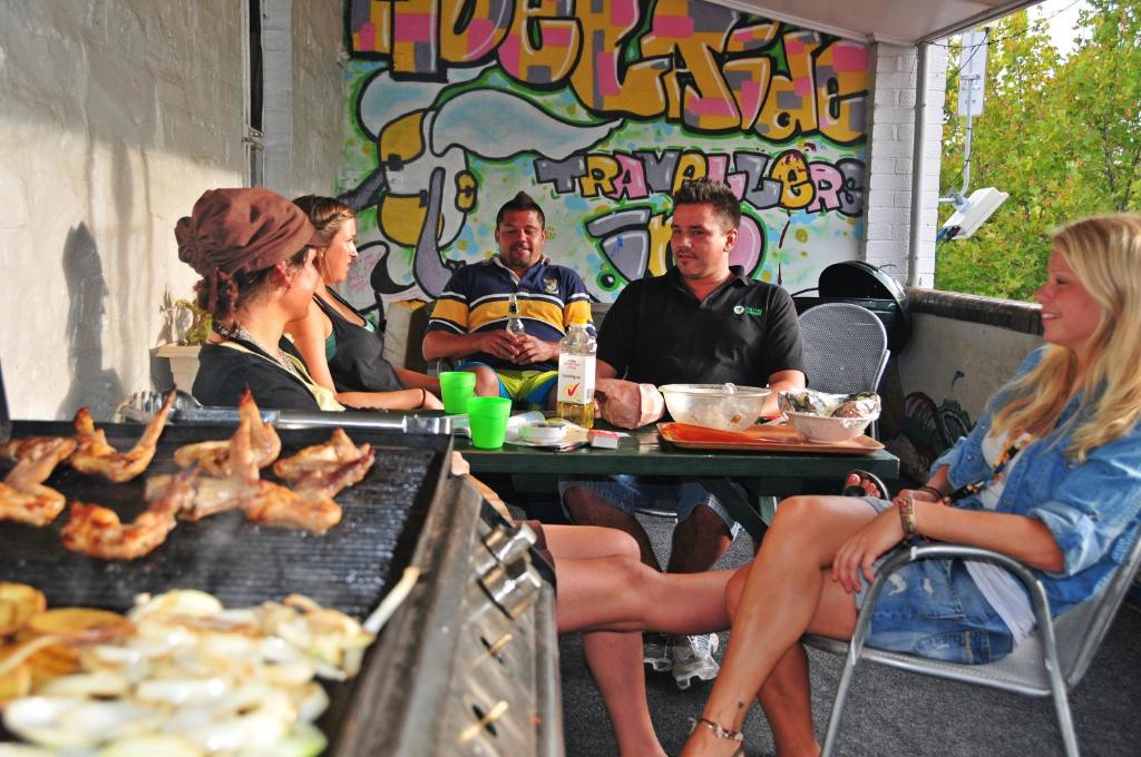阿德莱德阿德莱德旅行者背包客旅馆的一群人坐在烧烤架附近的桌子旁