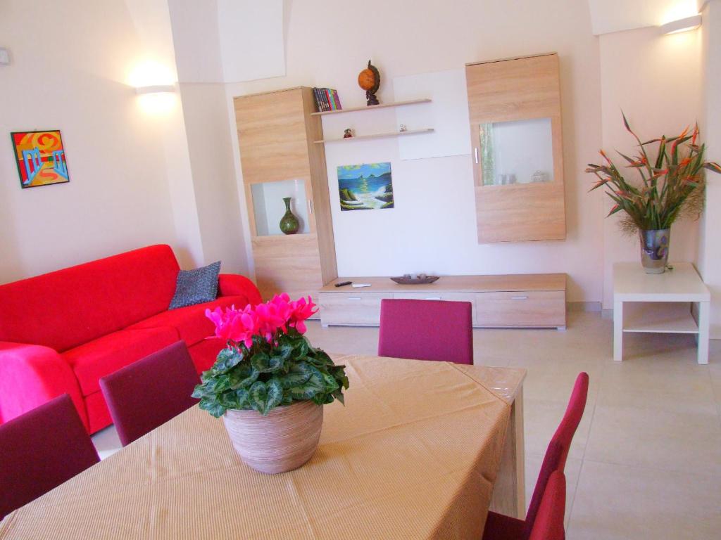 莱韦拉诺Casa Donna Rita的客厅配有桌子和红色沙发