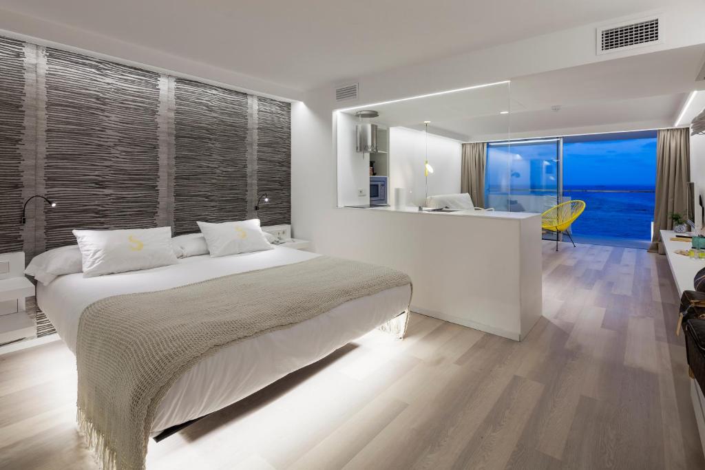 伊维萨镇南伊维萨公寓式酒店的一间卧室配有一张床,厨房享有美景。