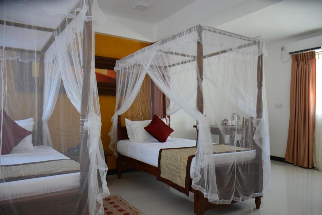 康提梅里兰卡城市酒店的一间卧室配有两张带蚊帐的床