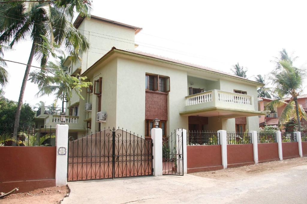 波尔沃林KD's Villa - North Goa的白色的房子,有门和栅栏