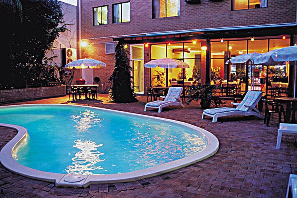 珀斯珀斯城市公寓酒店 的一座带桌椅的游泳池以及一座建筑