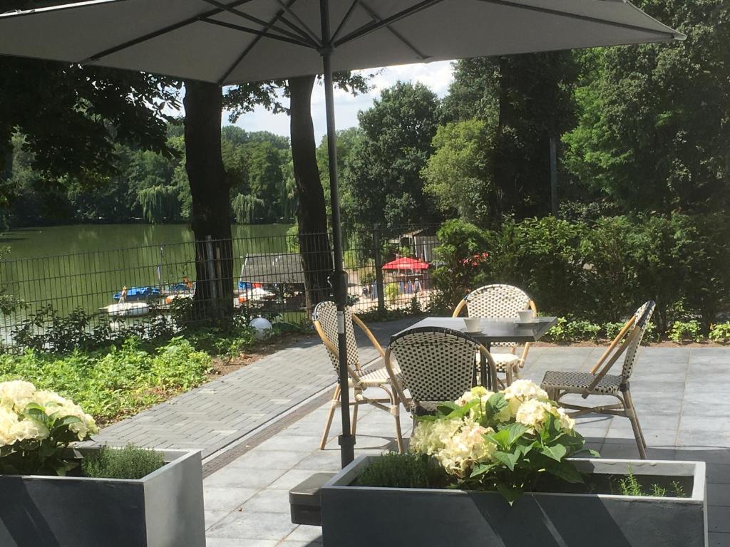 阿尔斯多夫博泰酒店的庭院配有桌椅和遮阳伞。