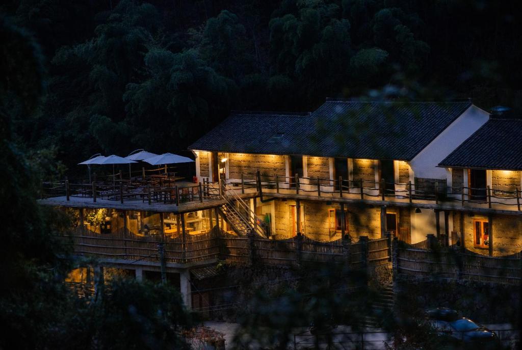 德清莫干山唯乐山居精品酒店的一座晚上点亮的建筑,灯火通明