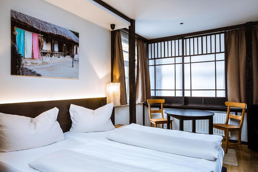 斯塔德哈根祖尔安特斯伯弗特酒店的酒店客房设有两张床和一张桌子。