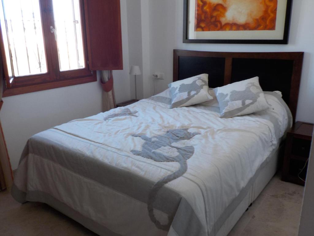 卡拉德米哈斯纳维戈夫公寓的一间卧室配有一张带白色床单的大床