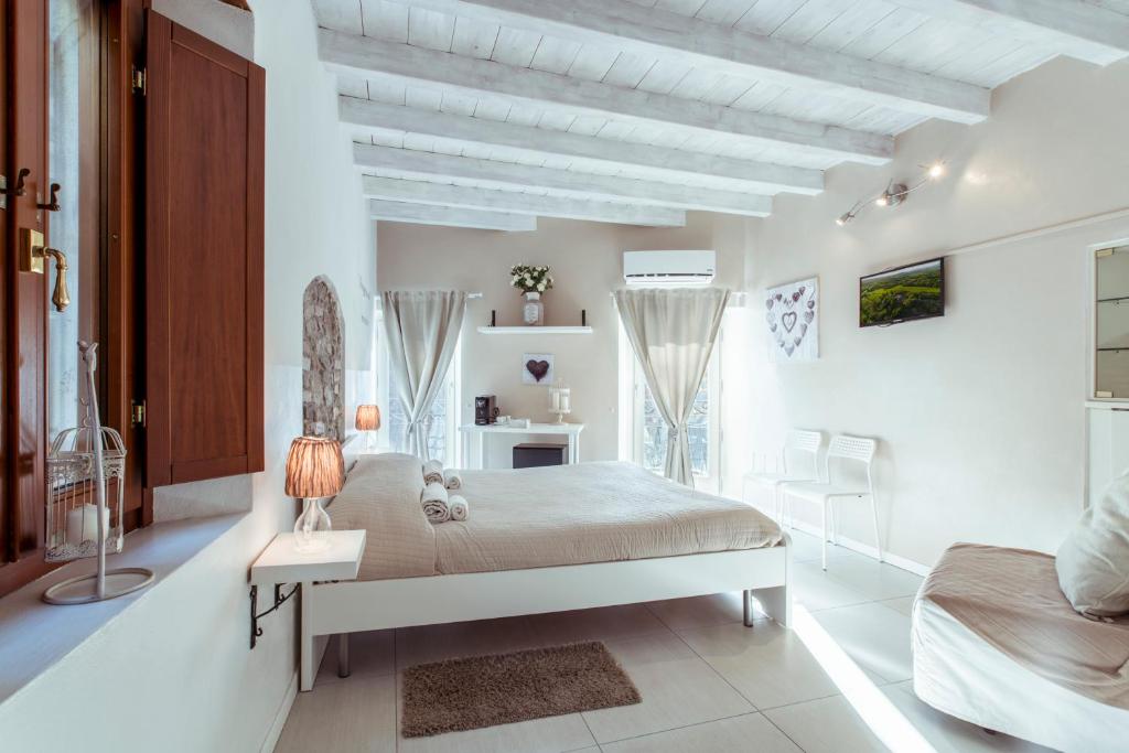 代森扎诺-德尔加达La Piccola Matilde的白色卧室配有床和桌椅
