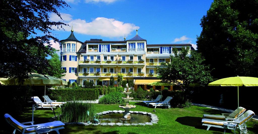 巴特沃里斯霍芬丰特奈城堡酒店的一座大建筑,设有庭院、椅子和喷泉