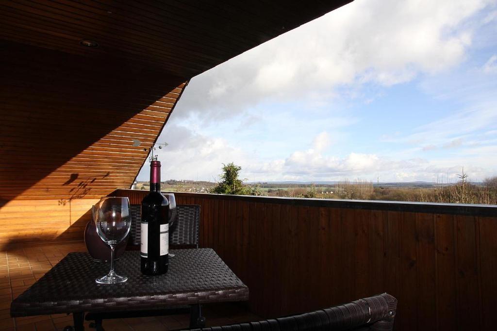 索勒恩Ferienwohnung Panoramaweg的一张桌子,上面放着一瓶葡萄酒和一杯