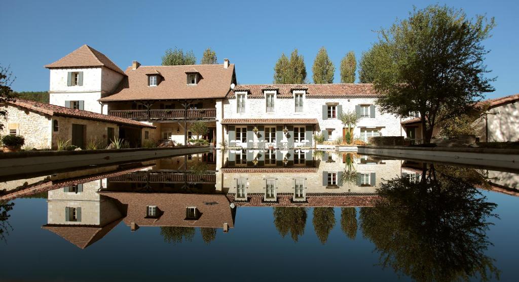 安敦特里古南特Le Mas Des Bories - Grand Perigueux的水体中的房屋及其反射
