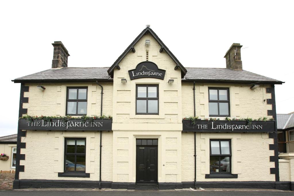BealThe Lindisfarne Inn - The Inn Collection Group的一座白色的建筑,设有Lindisfarne宾馆的入口