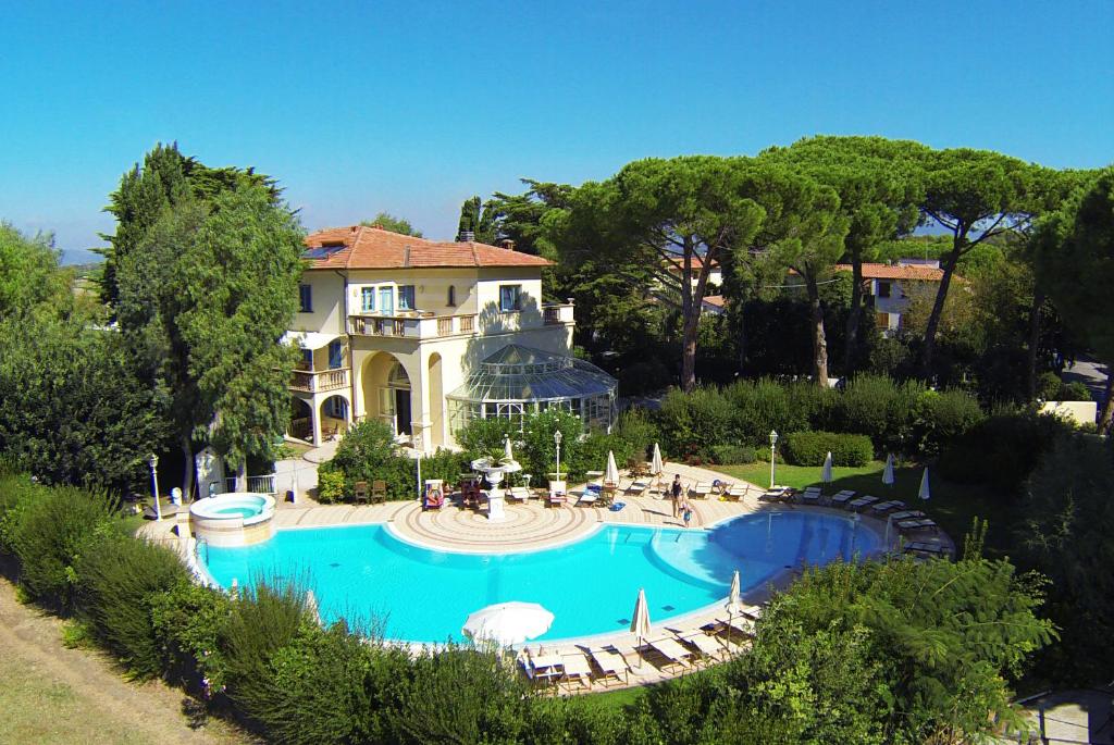 瓦达Villa Mazzanta Relais & Residence的一座大房子,前面设有一个游泳池