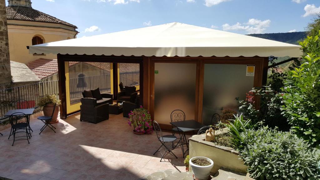 San Chirico Raparo罗莎玛丽亚别墅酒店的庭院设有白色遮阳篷和桌椅。