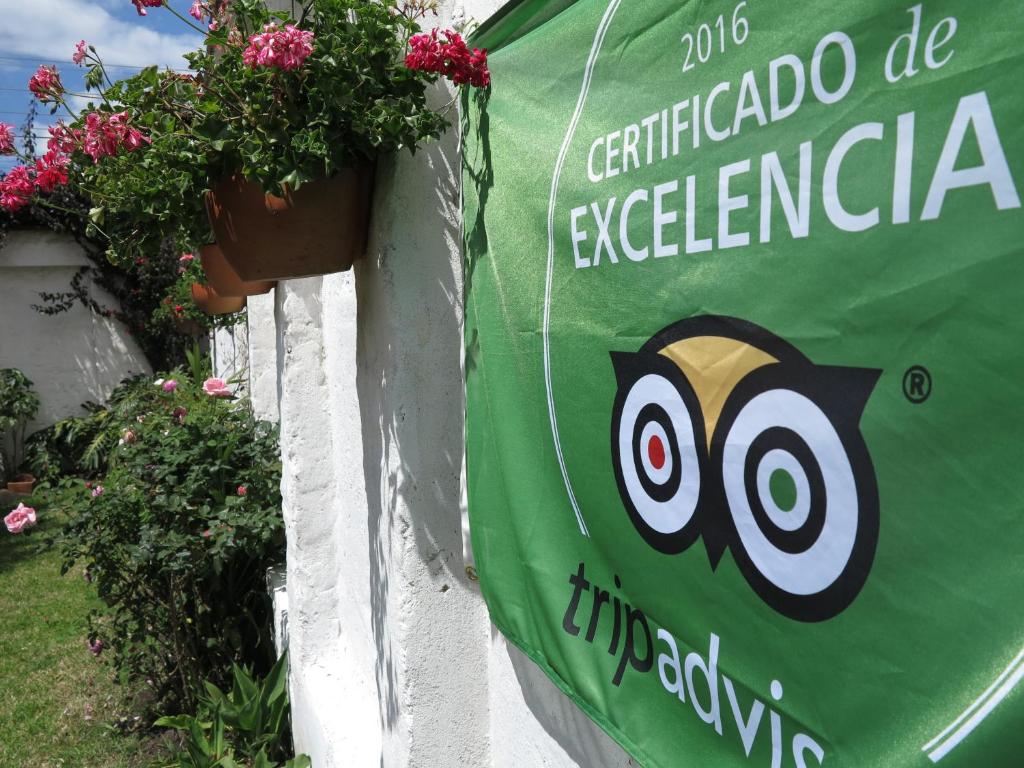 索加莫索Hostal La Cazihita的花墙上的绿色标志,上面有猫头鹰
