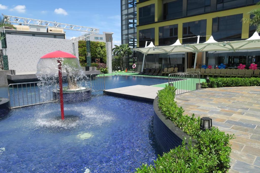 嘉义市乐亿皇家渡假酒店  的游泳池中间带红伞的喷泉