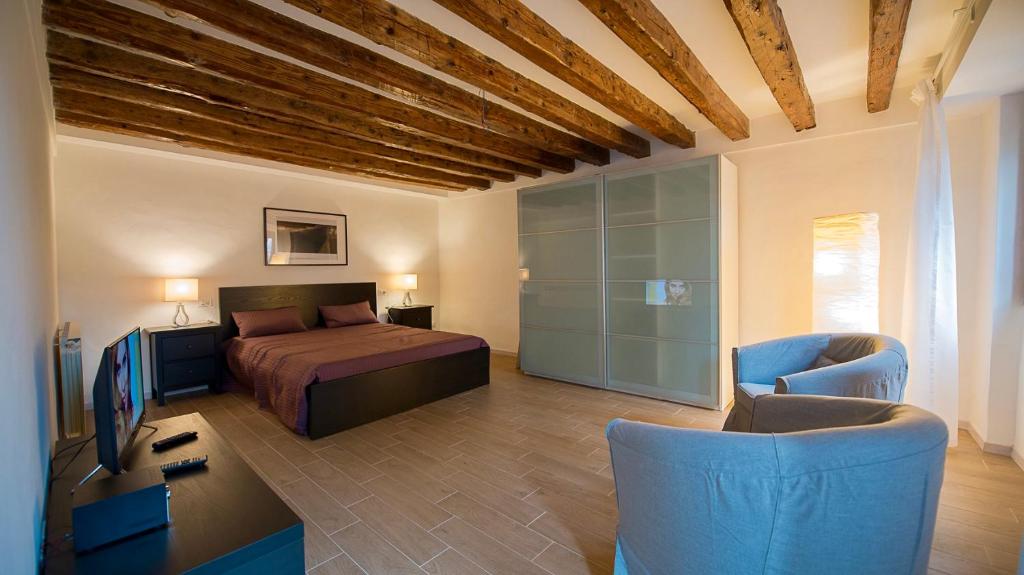 威尼斯Ca' Moretta的一间卧室配有一张床、一张书桌和一台电视。