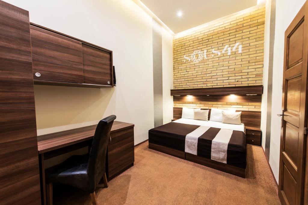 布达佩斯苏斯44号酒店的配有一张床和一张书桌的酒店客房