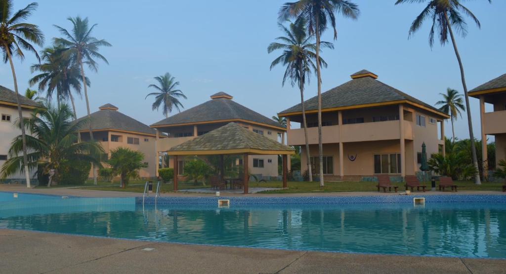 ElminaElmina Bay Resort的一个带游泳池和棕榈树的度假村