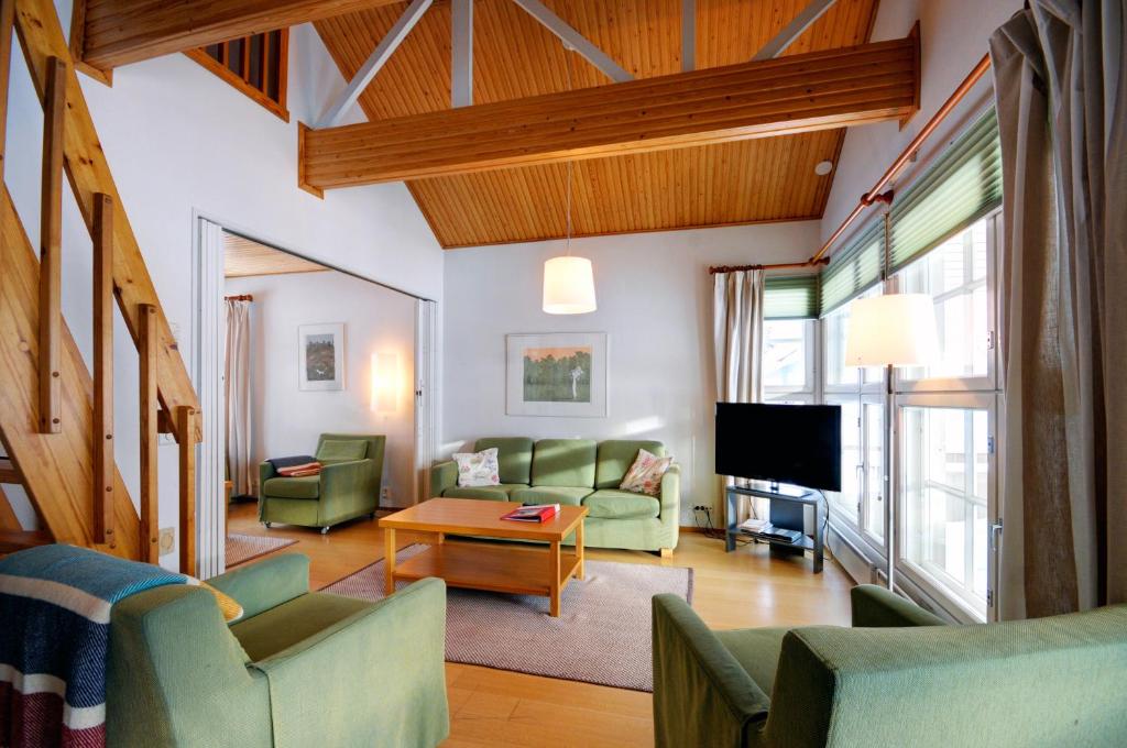沃卡蒂Katinkulta Apartments的客厅配有绿色家具和电视