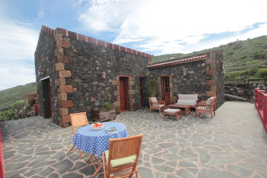 莫卡诺尔Casa Rural la Hojalata的一个带桌椅的庭院和一座建筑