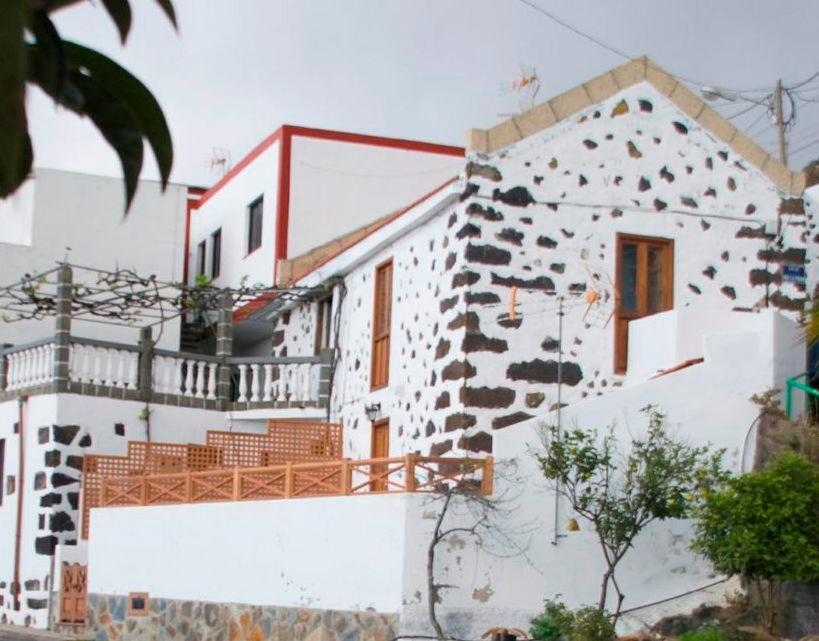 弗龙特拉Casa Rural de 1945 Dos Plantas Patio Y Barbacoa的白色的房屋,设有岩石墙
