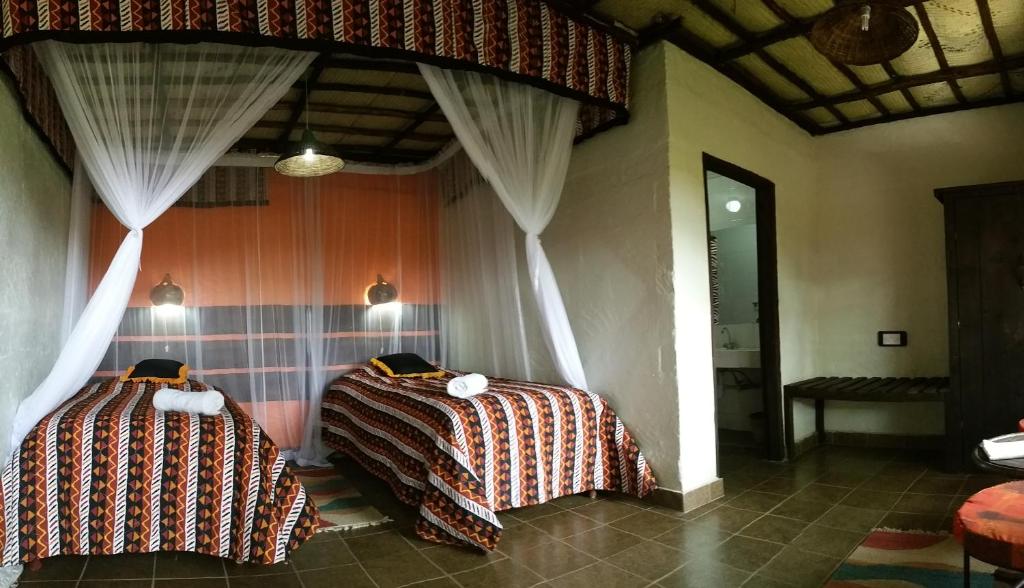 内罗毕奥索伊塔旅馆的两张床铺,位于带窗帘的房间