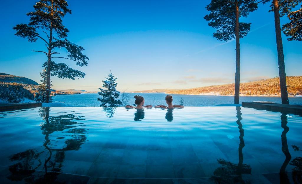 Vallsta欧巴登Spa及度假村的两人坐在无边游泳池里