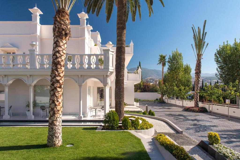韦托维加Quinta Real Granada的一座大白色的豪宅,在院子里种有棕榈树