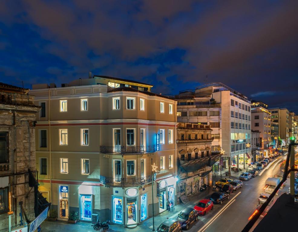 雅典莲花酒店的夜间有建筑物和汽车的城市街道