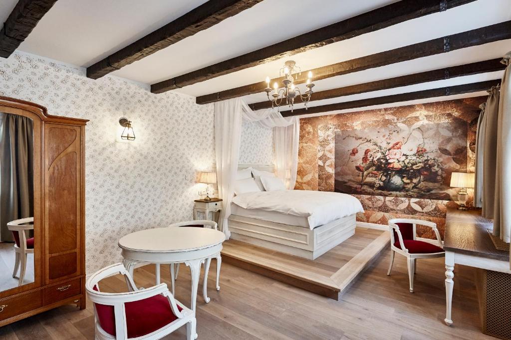 布达佩斯麦森酒馆及酒店的卧室配有一张床和一张桌子及椅子