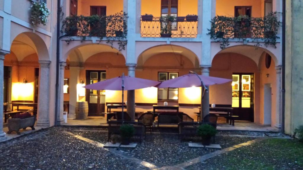 韦尔巴尼亚Archi e Colonne的一座带桌子和遮阳伞的庭院
