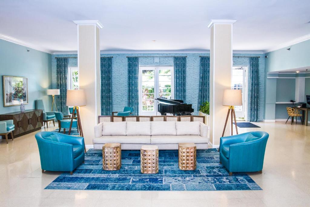 迈阿密海滩多切斯特套房酒店的客厅配有白色沙发和钢琴