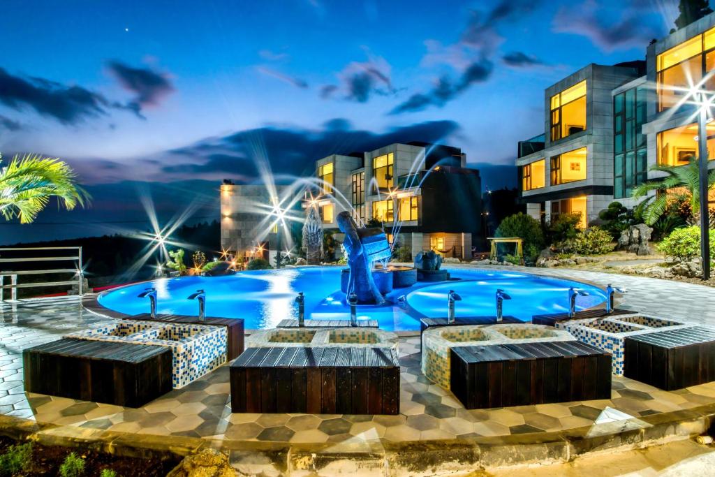 西归浦市多尼克希尔度假村的一座建筑前的游泳池,设有4个喷泉