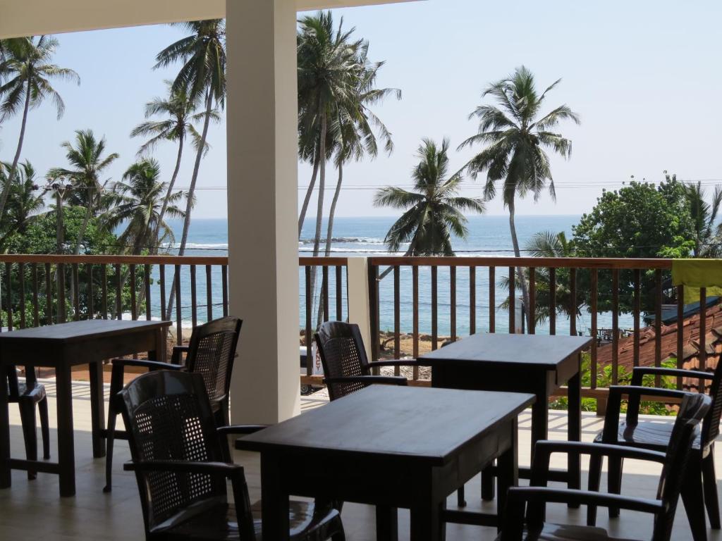 米瑞莎美蕊沙水手旅馆的一个带桌椅的庭院和海滩
