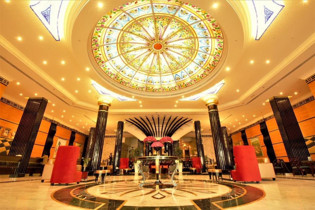 沙迦Red Castle Hotel的大型大堂设有天花板和大窗户