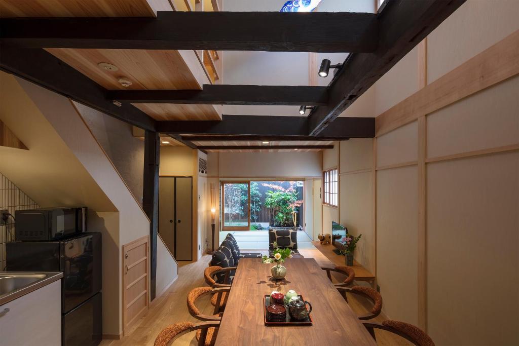 京都嵨原怀传町家的用餐室配有长木桌子和椅子