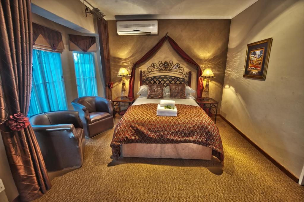 布隆方丹Dias Guest House的配有一张床和一把椅子的酒店客房