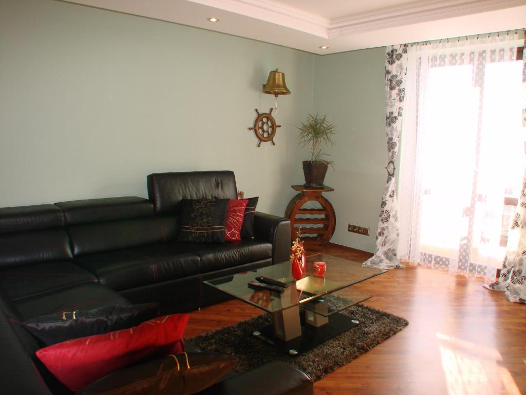 Vysoke Tatry - Horny SmokovecApartments Vysoké Tatry的客厅配有黑色真皮沙发和桌子