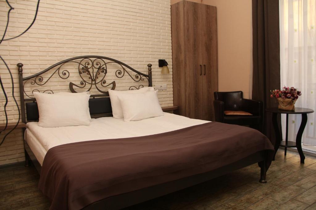 第比利斯得利斯酒店 的一间卧室配有一张大床和一把椅子